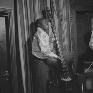 Double bass player. An African musician smiles broadly as he plays a double bass during a