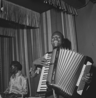 Accordion player. An African musician smiles broadly as he squeezes an accordion during a