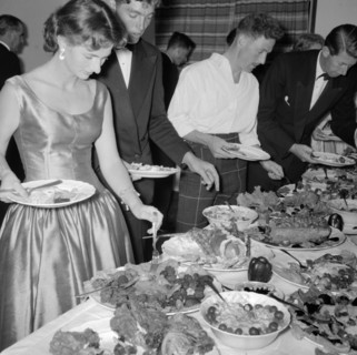 Buffet supper. Formally dressed guests at the Orme-Smith 21st birthday party queue up to help