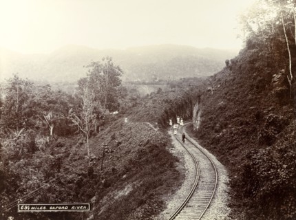 Railway track at Oxford River. A group of children play on the lines of a railway track cut into