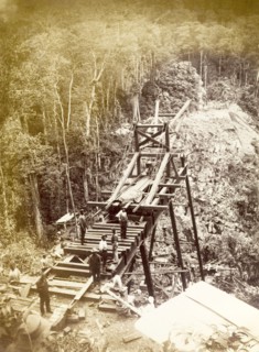 Railway viaduct under construction. Labourers work on the construction of a new trestle bridge over