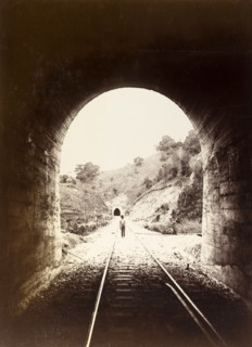 Railway tunnel, Jamaica. View from inside a railway tunnel looking out towards a man who stands on