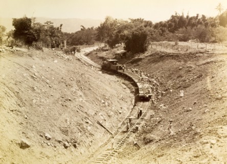 Rail track construction, Jamaica. Labourers at a railway construction site pile discarded rubble