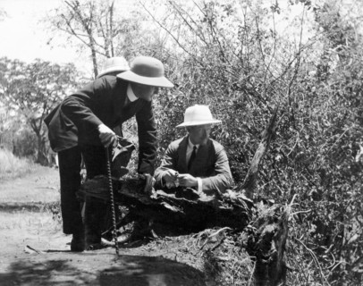 Admiring the Victoria Falls. Three European men perch on the edge of a cliff as they admire a view