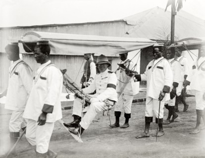 Duke of Connaught in a portable hammock. A smiling Duke of Connaught is carried along in a portable
