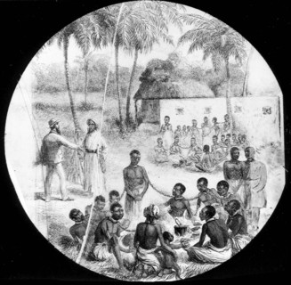 An African slave market. Groups of African slaves sit on the ground, chained together by the neck,