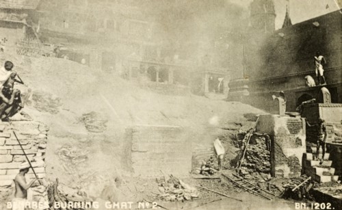 A cremation ghat in Benares. Smoke obscures the view of a cremation ghat (stepped wharf) on the
