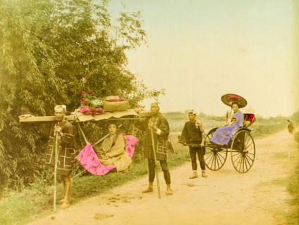 Travelling in style. Two young Japanese women, finely dressed in traditional kimonos, travel in