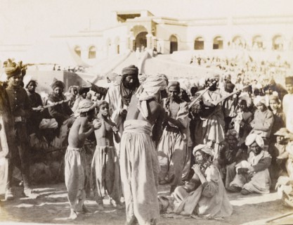 Musicians perform in Sukkur. Spectators at an outdoor event gather to listen to a group of
