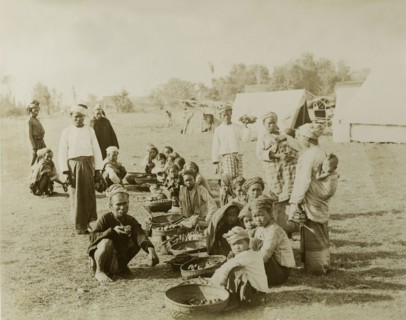 An outdoor bazaar at Wuntho. A line of women and children sell food from baskets on the ground