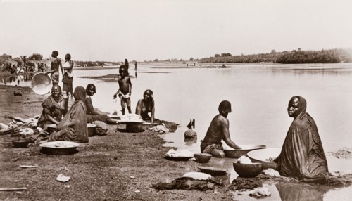 Washing clothes at the river bank, Sudan. Sudanese women and children wash their clothes on the