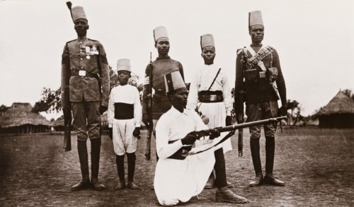 Sudanese military uniforms. Five Sudanese men and a young boy pose for the camera, wearing a