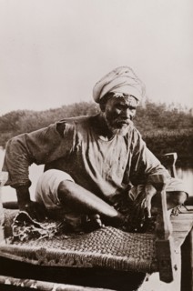 An elderly Sudanese guide. Portrait of an elderly Sudanese guide sitting cross-legged on a woven