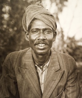Portrait of a 'shikari'. Portrait of a smiling 'shikari' (hunter), wearing a Western-style suit and