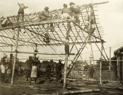 Building a spectator stand for the royal visit. A team of Ceylonian men construct the frame of a