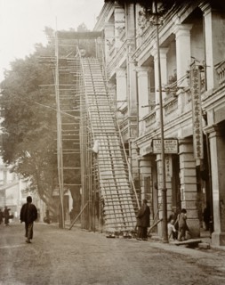 Staircase for a coffin. A coffin sits at the top of a makeshift staircase attached to the exterior