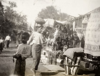Fish festival in Shwezayan. A Burmese woman balances a ceramic pot on her head as she walks past