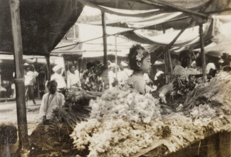Flower stall at Taungbyon Festival. A Burmese woman arranges bundles of flowers on a stall at the
