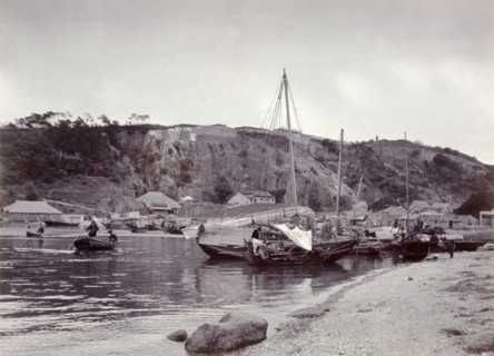 Sampans at anchor in Shau Kei Wan bay. Several small sampans sit at anchor on the sandy shore of