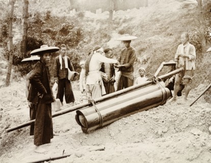 A working-class Chinese funeral. A group of mourners, including one paid mourner dressed in white,