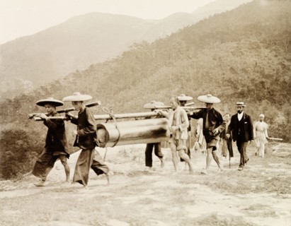 A working-class Chinese funeral procession. Four pallbearers carry the simply-constructed coffin of