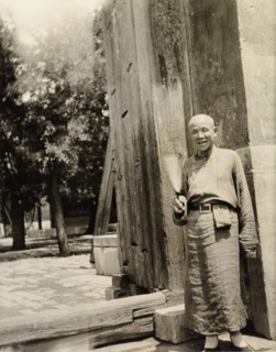Lama priest at the doorway to a temple. A 'lama' (Buddhist monk) stands at the entrance to a temple