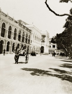 Rickshaw on the 'praya' in Macao. A rickshaw travels along the 'praya' (waterfront promenade) in
