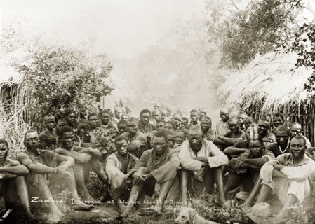 Acutt and Crewes labourers. A number of hired labourers sit on the ground in a scrubland clearing