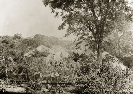 Acutt and Crewes labourers. A number of hired labourers sit on the ground in a scrubland clearing