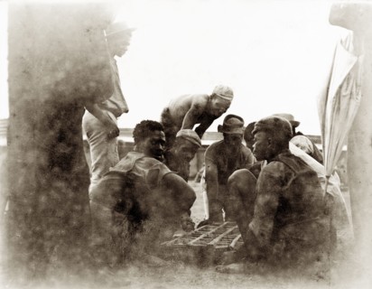 Off-duty diamond mine workers. African workers from the De Beers diamond mines sit around a small