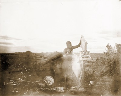 Matabele woman using a mangle. A Matabele (Ndebele) woman uses a mangle to wring water from a piece