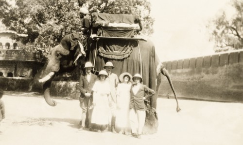 Europeans take an elephant ride. A group of European people pose for a photograph in front of an