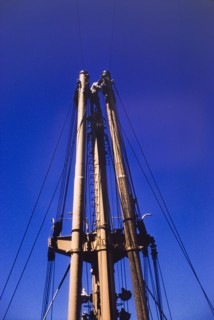 Sailor on the mast of M.V. Obuasi. A sailor stands at the top of a ladder on the stern mast of a