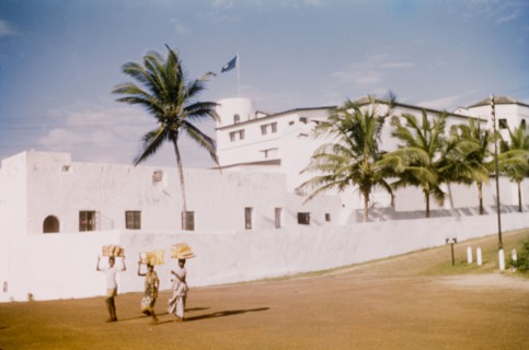 Breadsellers at Elmina Castle. Three breadsellers walk along a road adjacent to Elmina Castle.