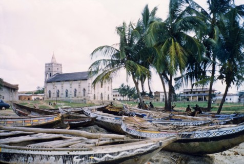 Painted fishing boats at Anomabu. A collection of painted fishing boats lie on the sand close to a