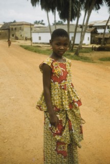 The red earrings'. Portrait of a Ghanaian girl standing on a road in Anomabu. She wears a two-piece
