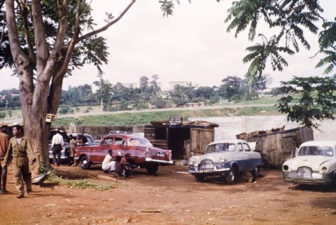 Car workshop in Kumasi. Mechanics work at a roadside car repair workshop. Kumasi Hospital is just