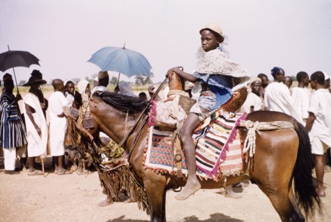 Boy riding a caparisoned pony. A boy, possibly the son of a chief, rides a caparisoned pony at