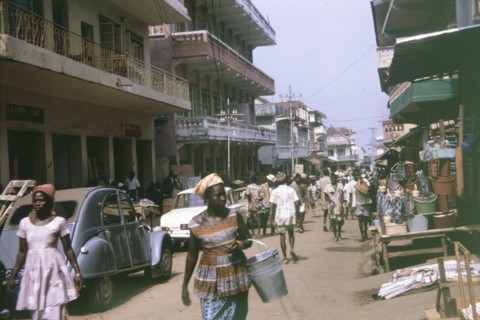 Busy urban street in Freetown. Pedestrians and road traffic crowd a busy urban street in Freetown,