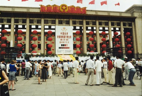 Celebrating the handover of Hong Kong. A crowd of people gather in a piazza outside a building