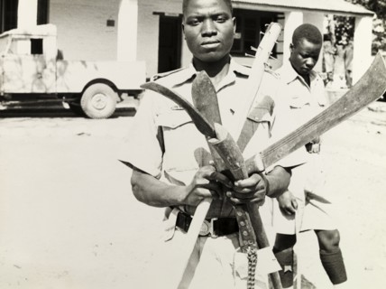 Confiscated weapons, Northern Rhodesia 1964. An officer of the Northern Rhodesia Police Force holds