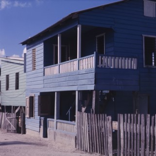 A blue house in Belize. Exterior view of a wooden, two-storey house in Belize. The building has