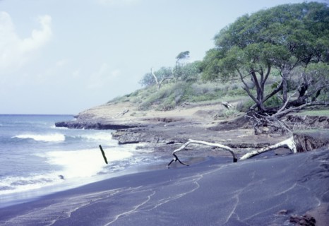 Black sand beach in Grenada. View across a beach of volcanic black sand. Grenada, circa 1975.