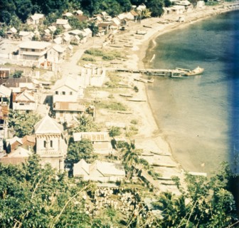 Coastal settlement in Dominica. View across a coastal settlement and beach bordering the Caribbean