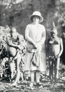 A British woman poses with "pigmy women". A British woman poses for a portrait in between two
