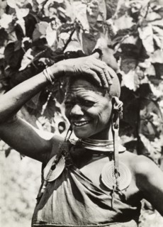 One of Chief Murigo's 19 wives'. Portrait of a Kikuyu woman, wearing several items of jewellery