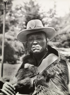 Chief Murigo. Portrait of Chief Murigo wearing traditional Kikuyu jewellery and holding a staff. He