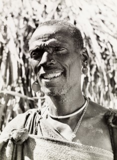 A Kikuyu witch doctor. Portrait of a smiling Kikuyu man, labelled in an original caption as a witch