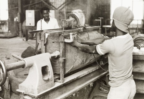Craftsman operating a lathe, Ghana. A craftsman operates a wood-turning lathe to shape a section of