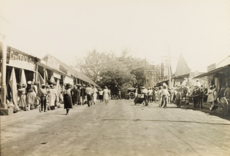 Commercial street in Jamaica. Customers browse at open-fronted shops on a commercial street in
